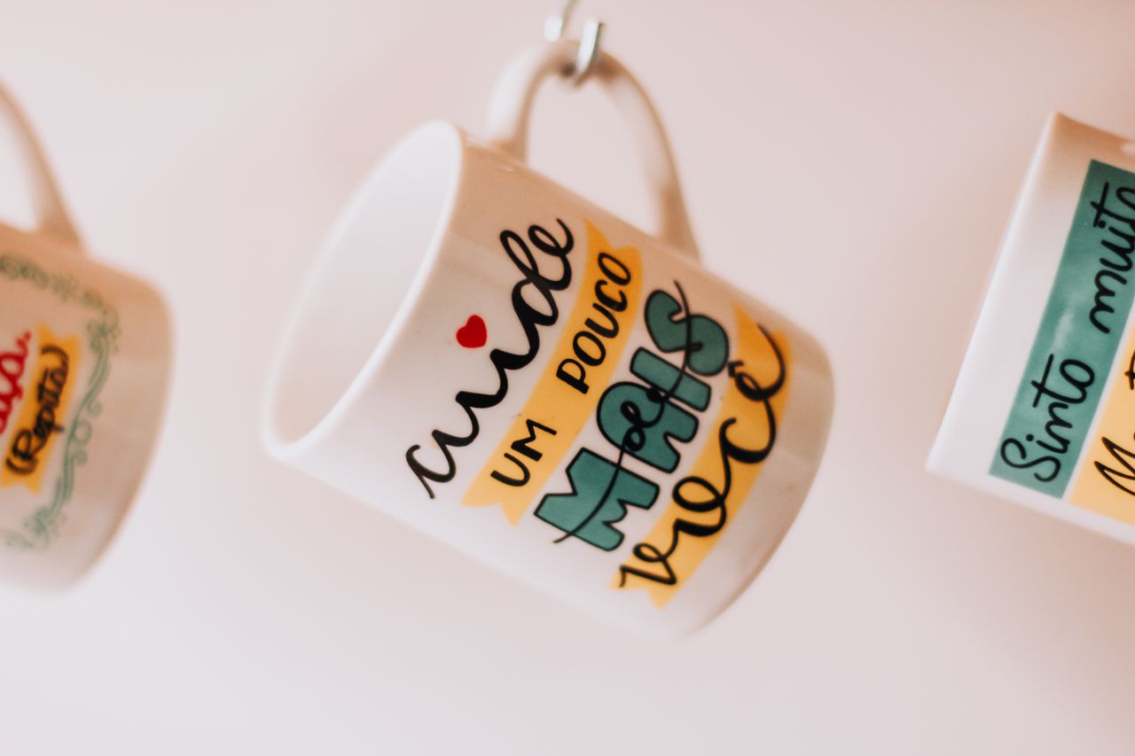 gallery-05 Close-up of hanging mugs with motivational text in São Paulo, Brazil.